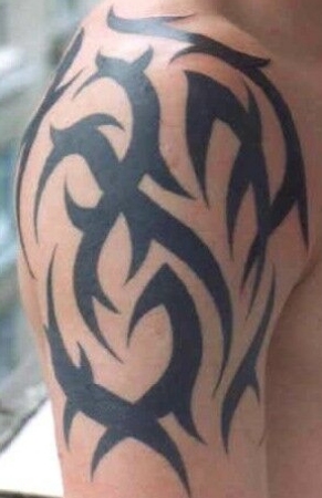 Photo of an arm and chest tribal tattoo